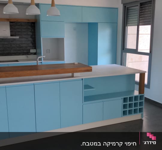 מטבח חדש עם ארונות כחולים ומשטח עץ